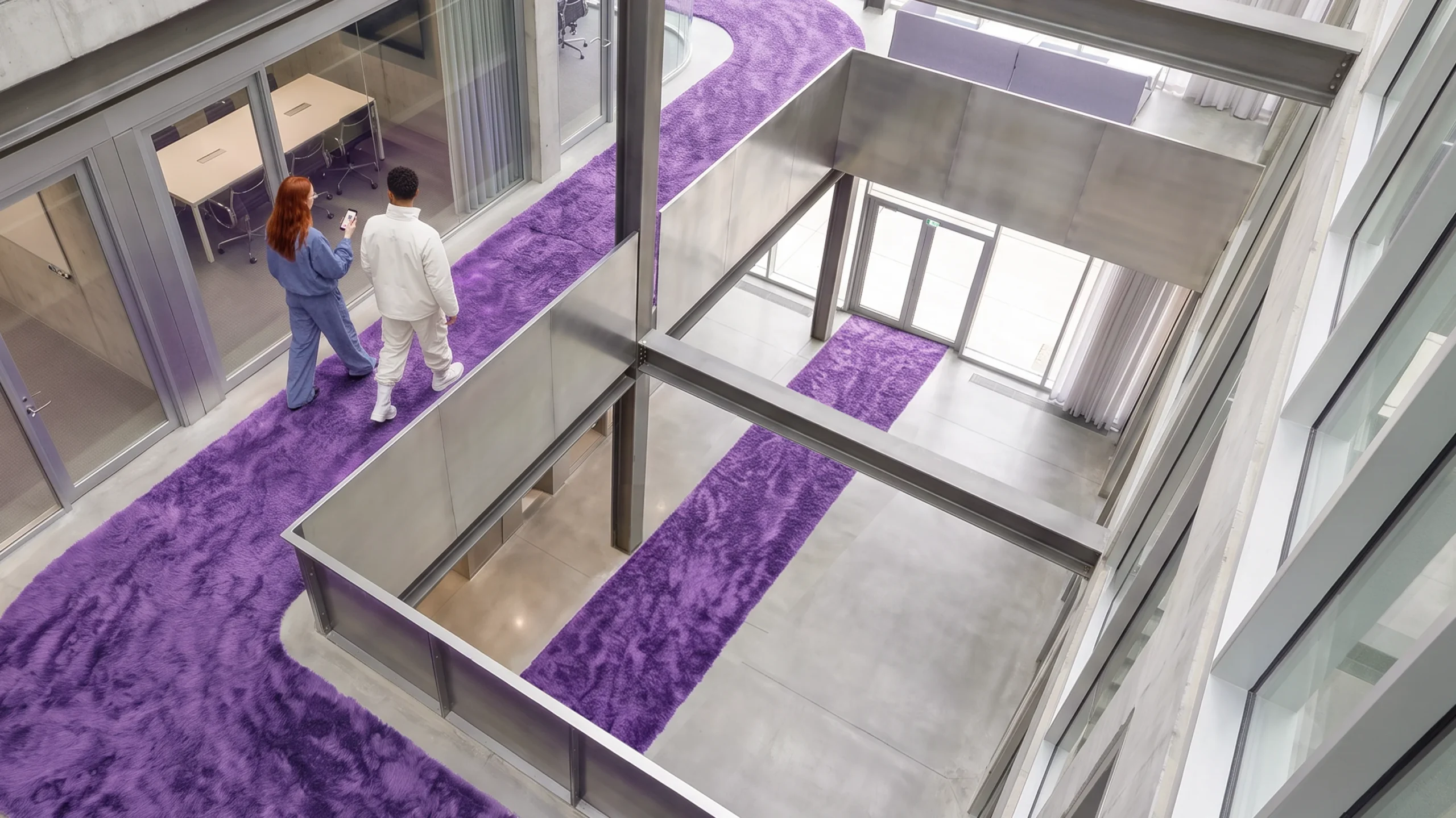 Équipe Dékuple traversant un atrium sur un chemin de tapis violet